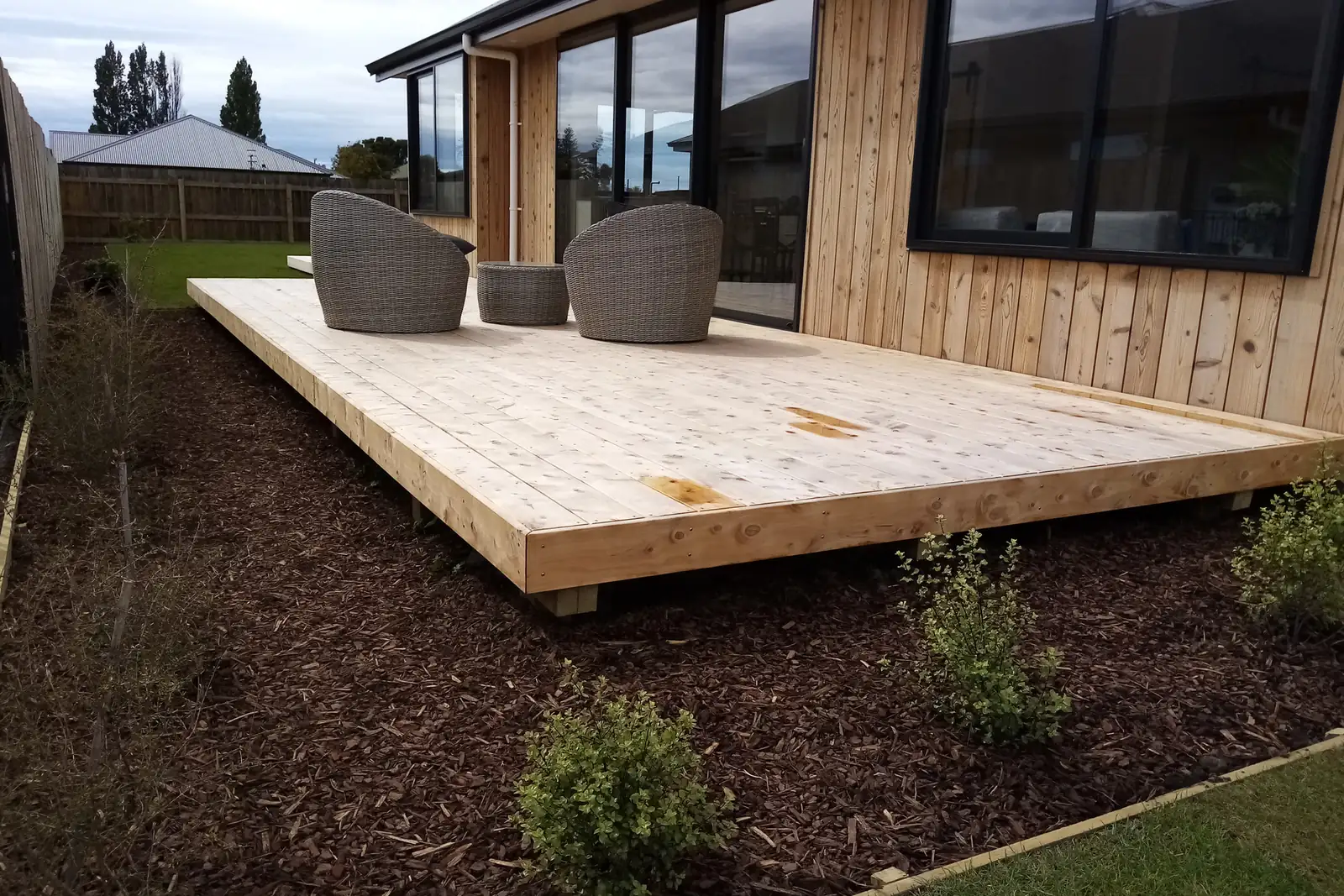 A new timber deck built by Handy Property Care beside a cedar clad Tasman home