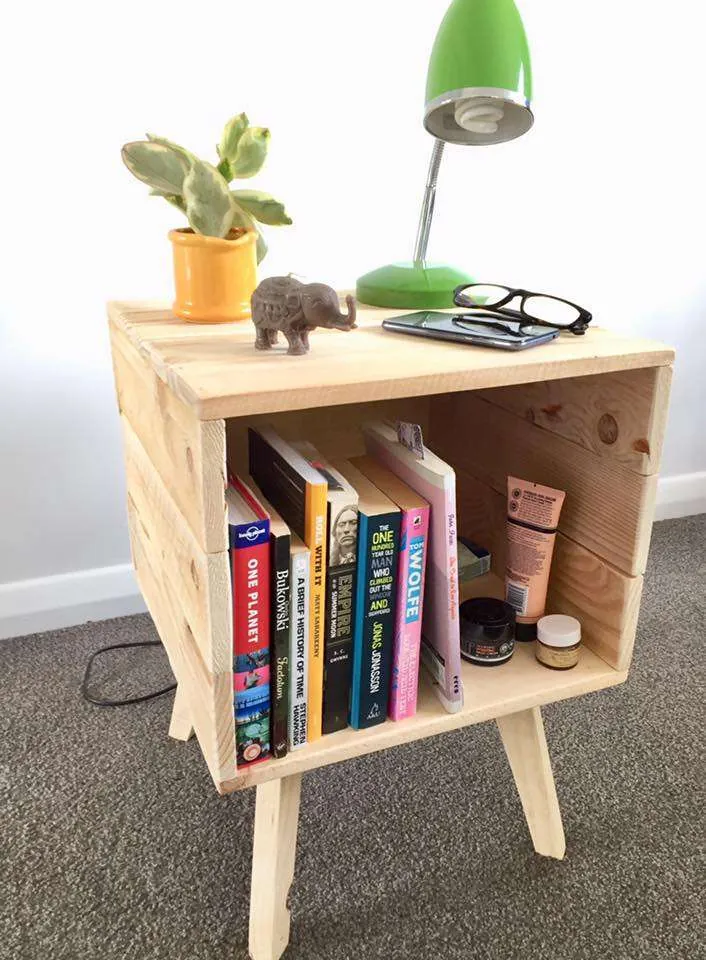 Handmade timber bedside table with books and a lamp