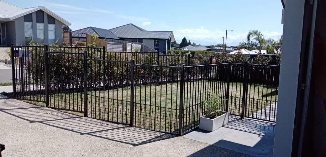Black aluminium pool and boundary fencing around a new build
