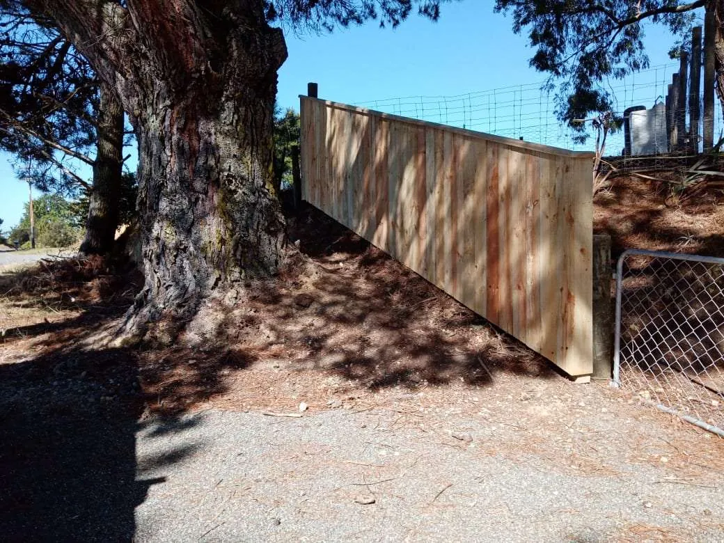 Long timber boundary fence built along a rural driveway