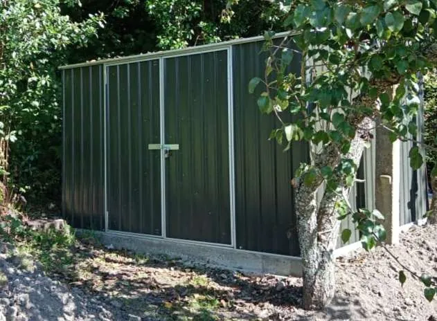 Green Colorsteel gate and fence panel fitted between block walls