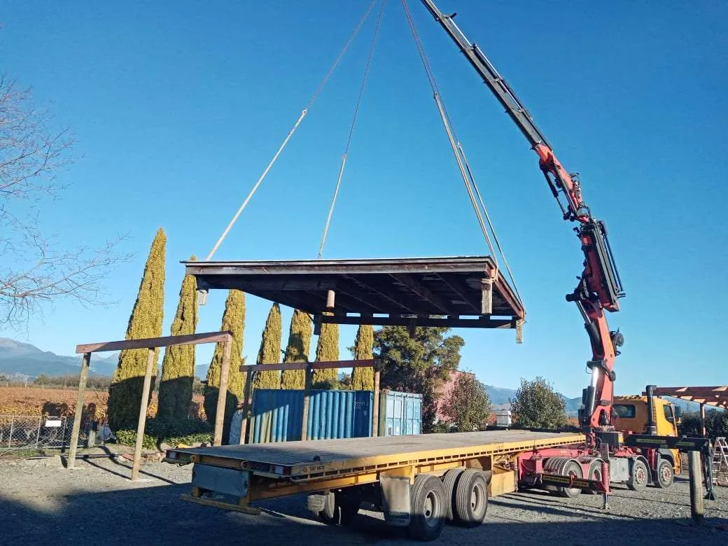 Crane lifting a prefabricated timber shelter into position